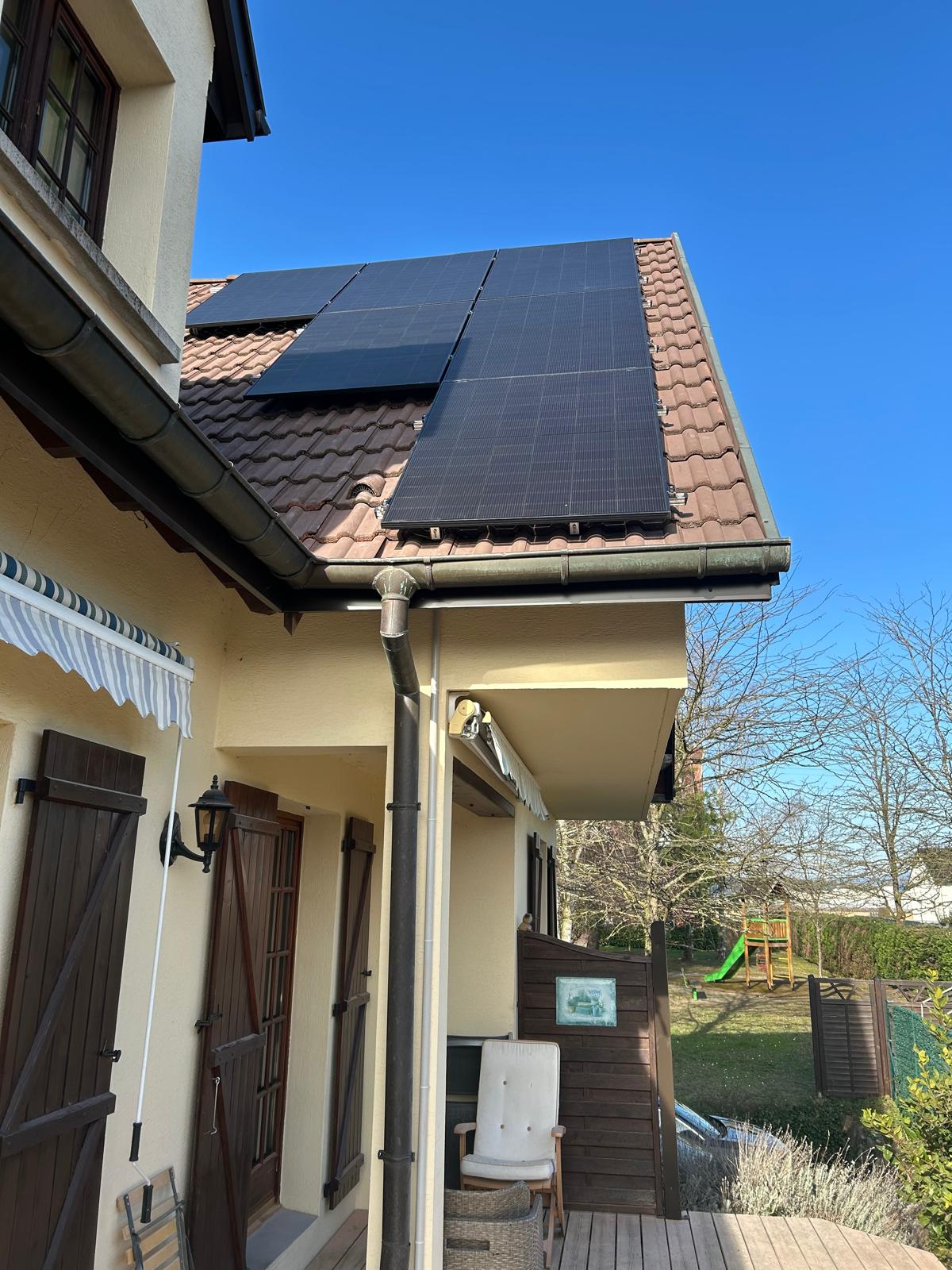 Installation de panneaux photovoltaïques sur toiture inclinée en tuiles par Wattsun68, maison avec terrasse et jardin à Hombourg